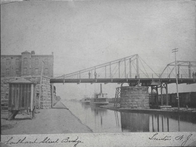 Bridge No. 8 at Southard Street in Trenton is seen in this 1880 photograph.  This bridge was a pivot type swing bridge, which was later replaced by a vertical lift bridge in 1922 that can be seen in Image 37